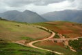 S curved country road cut deep through agriculture area into the valley of Andes mountains, Cusco, Peru Royalty Free Stock Photo