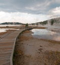 Curved Elevated wooden boardwalk going past Black Warrior Hot Springs and Tangled Creek into Hot Lake in Yellowstone National Park