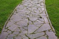 Curved garden path made of natural stone paved with different size rough rock. Royalty Free Stock Photo