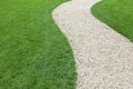 Curved garden stone path with fresh green cultivated lawn Royalty Free Stock Photo