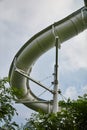 Curved Giant Water Slide with Green Foliage - Ground Up View Royalty Free Stock Photo