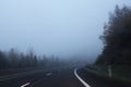 Curved higway landscape with fog and forest on sides Royalty Free Stock Photo