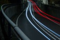 Curved light trails from car lights across the road