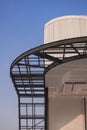 Curved metal awning structure with corrugated steel roof of modern building in construction site against blue sky Royalty Free Stock Photo