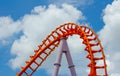Curved of orange Roller Coaster track in close up isolated on cloudy blue sky background. Royalty Free Stock Photo