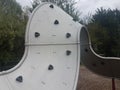 Curved playground climbing structure wall with hand and foot holds