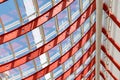 Curved red metal beams with perforation hold the window systems. Through the glass passes bright sunlight.Architectural Royalty Free Stock Photo