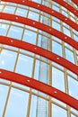 Curved red and white metal structures hold the window systems. Through the glass passes bright sunlight. Illustration of the Royalty Free Stock Photo