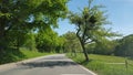 Curved road ahead There are green trees.