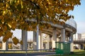 Curved road bridge arch in foreground of yellow tree leaves Royalty Free Stock Photo