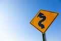 A curved road caution sign, blue sky with copy space Royalty Free Stock Photo