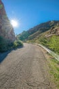 Curved road with sun peeking beside the rocky slope at Sabino Canyon State Park- Tucson, AZ Royalty Free Stock Photo