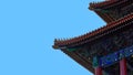 Curved roofs in traditional Chinese style with figures on the blue sky background.