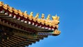 Curved roofs in traditional Chinese style with figures on the blue sky background. The Imperial Palace in Beijing Royalty Free Stock Photo