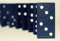 Curved row of black wooden dominoes standing on a white background. Logical Game. Business concept. Space for text