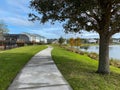 A curved sidewalk near a lake that is a walking path behind homes in an Orlando neighborhood
