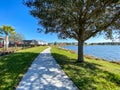 A curved sidewalk next to a lake that is a walking path in back of homes in Laureate Park