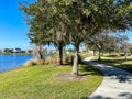 A curved sidewalk next to a lake that is a walking path in back of homes in Laureate Park