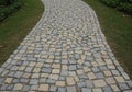 Curved stone pathway featuring interlocking square and rectangular stones in shades of Royalty Free Stock Photo