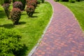 Curved stone tile pavement curved path in park landscaped. Royalty Free Stock Photo
