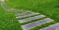 Curved stone walk path in the park with green grass Royalty Free Stock Photo