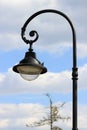 Curved street lamp against the sky with clouds Royalty Free Stock Photo