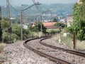 Curved train track disappearing next to the houses and vegetation in the city of Monforte de Lemos