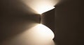 Curved wall sconce with a modern design casts light upward and downward, creating interesting Royalty Free Stock Photo