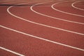 Curved white lines on a red rubber sports track