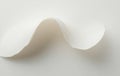 Curved White Paper Sheet Creating Abstract Wave Shape on White Background Royalty Free Stock Photo
