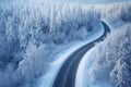 curved winding road through the forest up in the mountains in the winter with snow covered trees