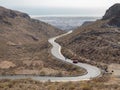 Curved winding road with a red car in the mountains in Gran Canaria