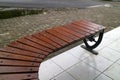 Curved Wooden Bench on Tiled Pavement Royalty Free Stock Photo