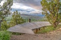 Curving elevated boardwalk descending into valley with tree