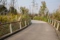 Curving fenced and planked path on hillside with pylons in sunny