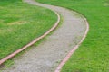 A curving gravel footpath with brick edging through park with green lawn/grass