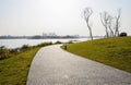 Curving lakeside path in lawn of sunny winter afternoon