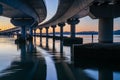 Curving lines and calm water under Tauranga Harbour Bridge at sunrise Royalty Free Stock Photo