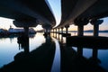 Curving lines and calm water under Tauranga Harbour Bridge at sunrise Royalty Free Stock Photo