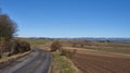 A curving minor road near Letham in Angus, wends its way towards a crossroads with a magnificent view of Mountains.