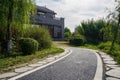 Curving path on slope before building with terrace in cloudy spring morning