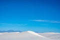 Curving Peak Of A Dune Under A Blue Sky