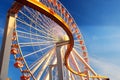 A curving rail cuts in front of a large Ferris wheel