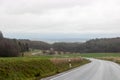 Curving road between fields and trees in Germany LanggÃÂ¶ns in Winter with Rain Royalty Free Stock Photo
