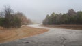 Curving road in the winter fog, dangerous driving conditions Royalty Free Stock Photo