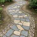 Curving stone pathway with alternating light and dark stones, Royalty Free Stock Photo