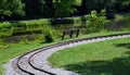 Curving Train Track Passes Park Bench