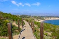 Curving walking trail at the beach with blue ocean water and blue skies