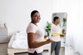 Curvy Afro woman measuring waist with tape near mirror, satisfied with weight loss result, achieving slimming success Royalty Free Stock Photo
