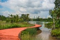 Curvy boardwalk beside the lake. Beautiful scenery with cloudy blue sky.